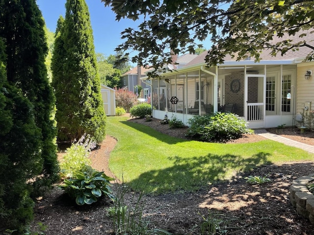 view of yard featuring an outbuilding, a sunroom, and a shed