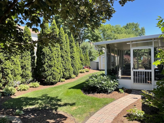 view of yard with a sunroom, an outdoor structure, and a storage unit