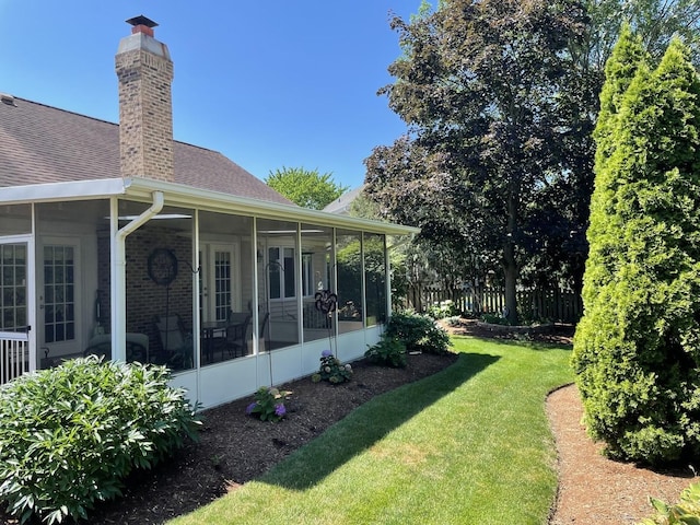 view of yard with fence and a sunroom