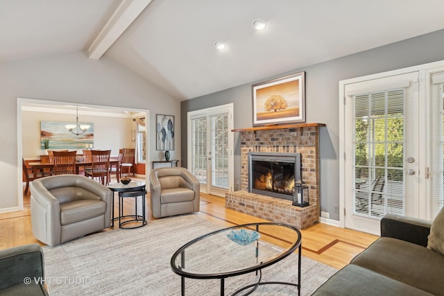 living room with french doors, lofted ceiling with beams, light wood-style floors, a brick fireplace, and baseboards