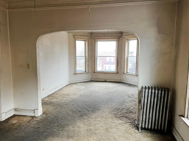 empty room featuring carpet flooring and radiator