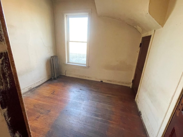 bonus room with radiator heating unit and dark hardwood / wood-style floors