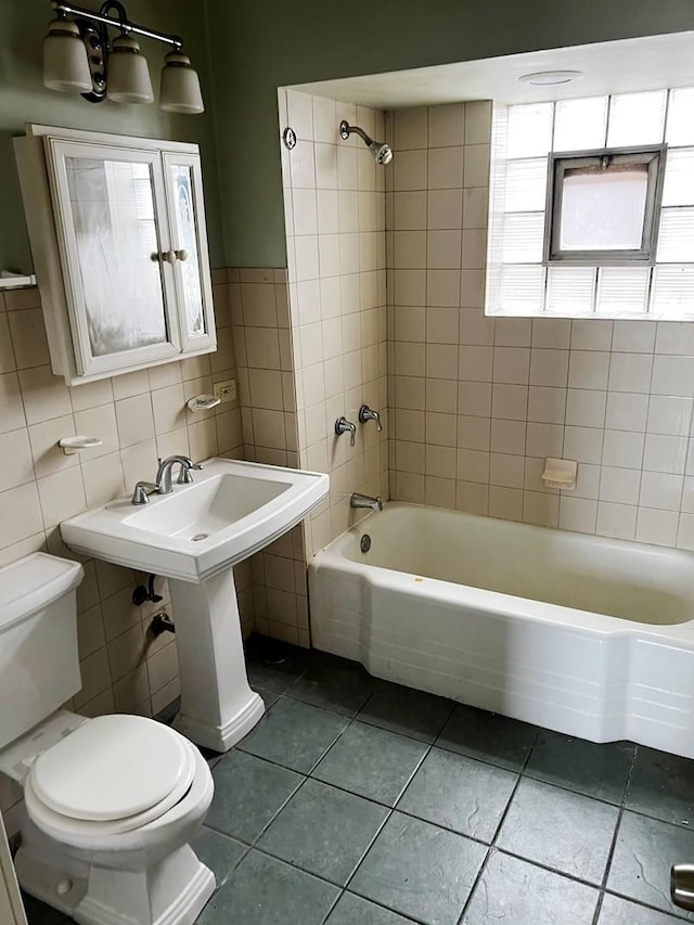 full bathroom with tile patterned flooring, tile walls, and toilet