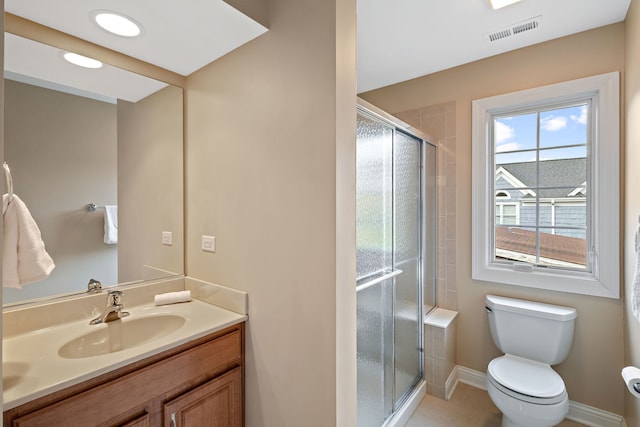 bathroom featuring tile patterned flooring, vanity, toilet, and an enclosed shower