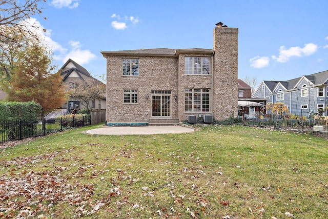 rear view of property featuring a lawn, a patio area, and cooling unit