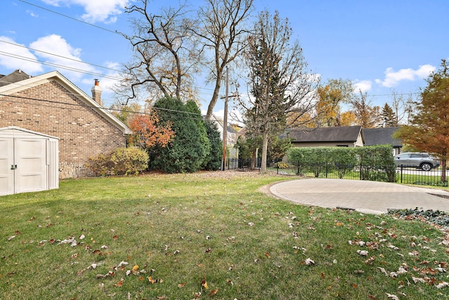 view of yard featuring a storage unit and a patio area