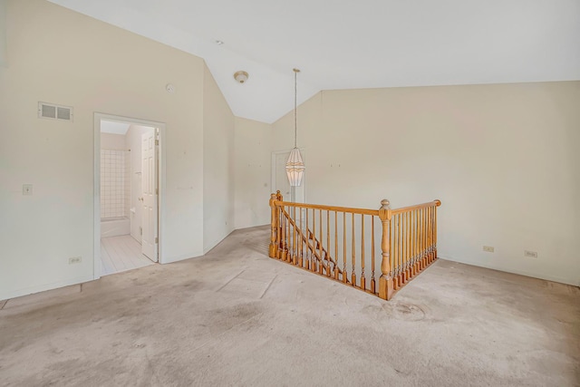 corridor featuring light carpet and lofted ceiling