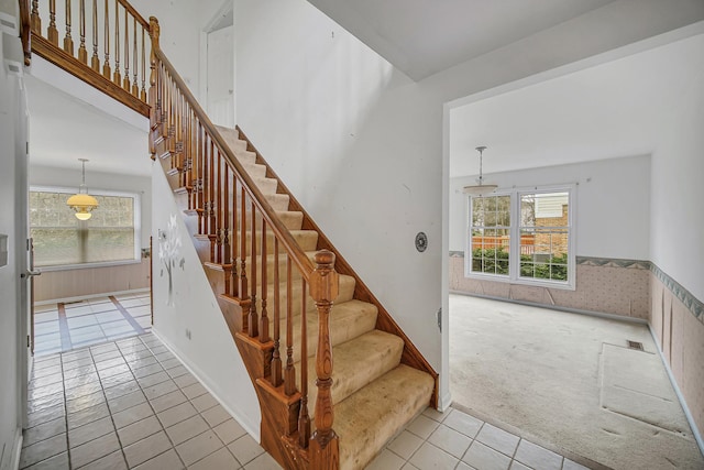 staircase featuring tile patterned flooring and a healthy amount of sunlight