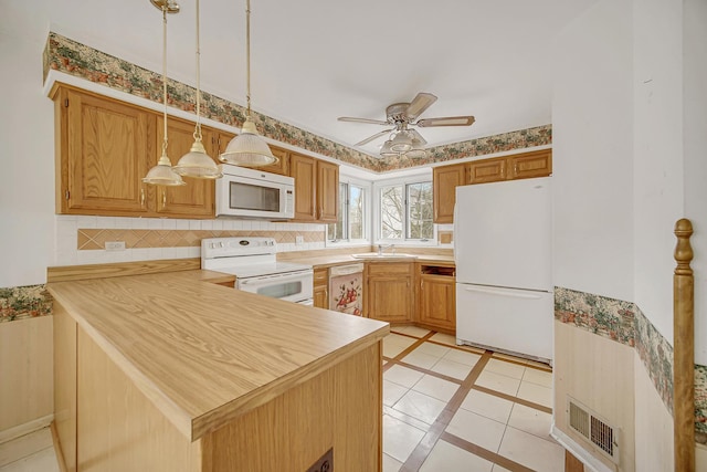 kitchen featuring ceiling fan, white appliances, kitchen peninsula, and hanging light fixtures