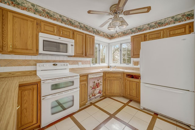 kitchen featuring ceiling fan, white appliances, sink, and light tile patterned floors