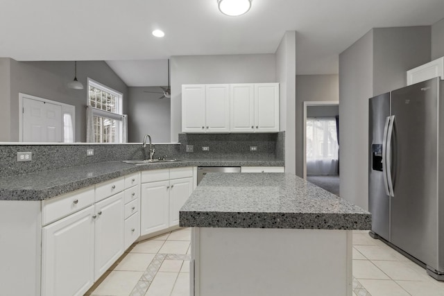 kitchen featuring a center island, stainless steel appliances, white cabinetry, and sink