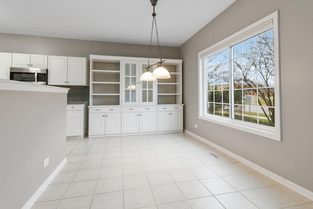 unfurnished dining area with plenty of natural light and light tile patterned flooring