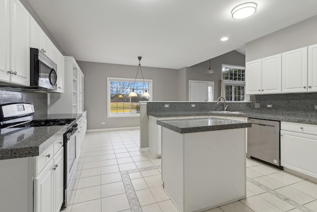 kitchen featuring a center island, white cabinets, sink, light tile patterned floors, and stainless steel appliances