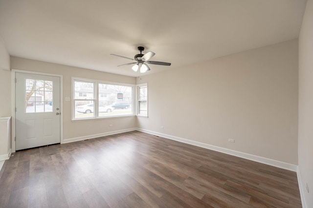 empty room with ceiling fan and dark wood-type flooring