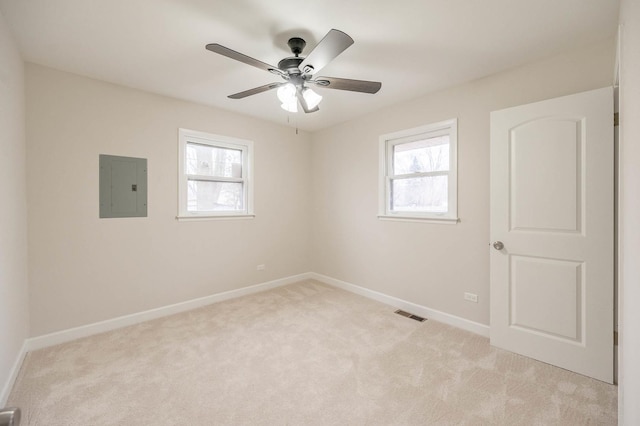 carpeted empty room featuring electric panel, a wealth of natural light, and ceiling fan