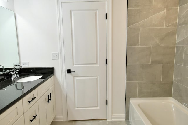 bathroom with tile patterned flooring, vanity, and tiled shower / bath combo