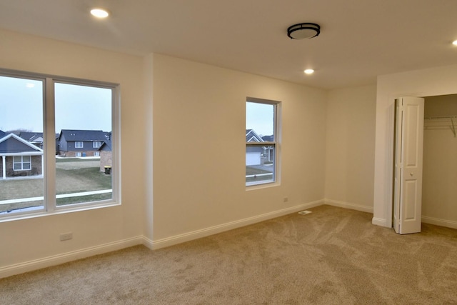 unfurnished bedroom with light carpet and a closet