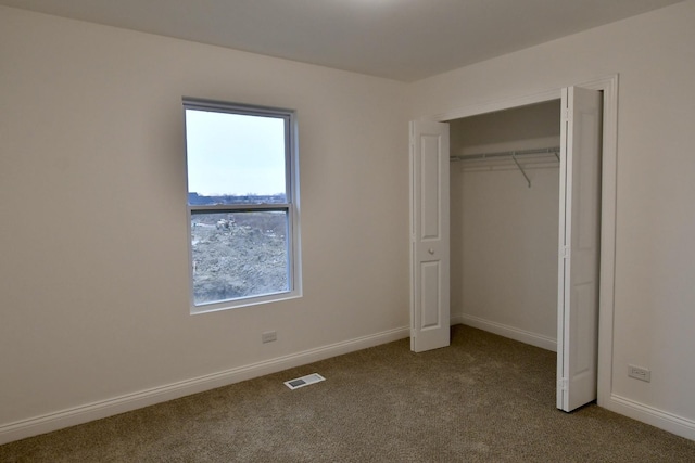 unfurnished bedroom featuring light carpet and a closet