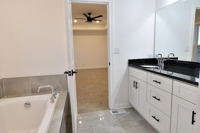 bathroom featuring tiled bath, ceiling fan, tile patterned flooring, and vanity