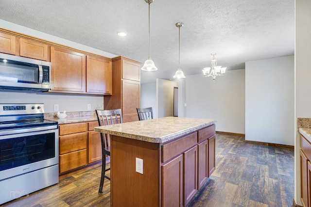 kitchen featuring a center island, stainless steel appliances, dark hardwood / wood-style flooring, a notable chandelier, and pendant lighting