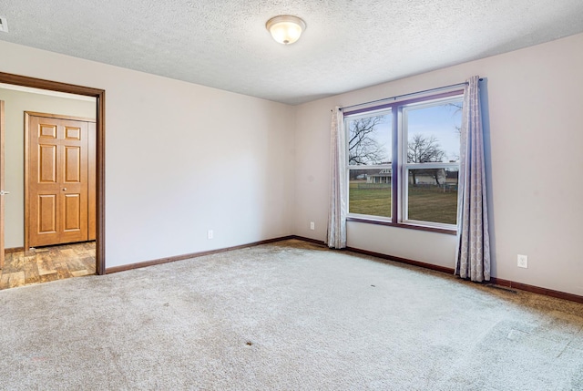 carpeted empty room with a textured ceiling