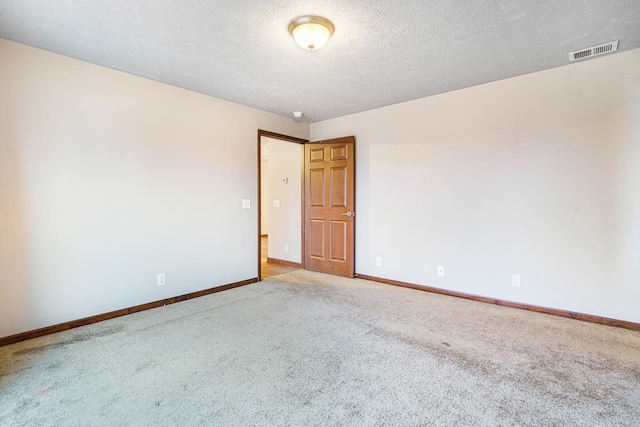 carpeted spare room featuring a textured ceiling