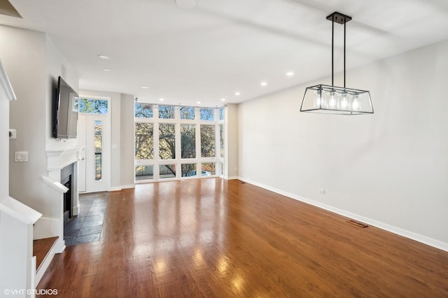 unfurnished living room with dark hardwood / wood-style floors and expansive windows