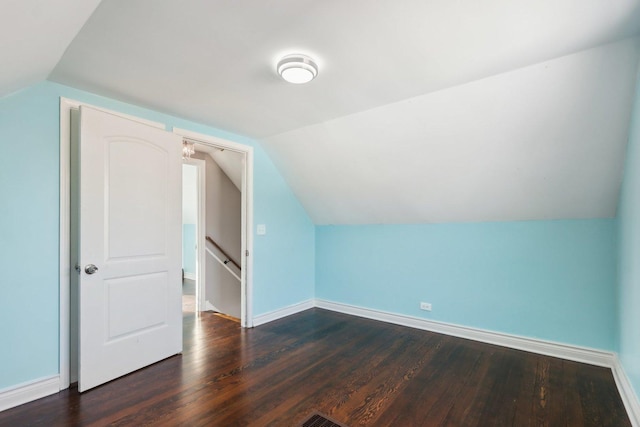 bonus room with dark wood-type flooring and vaulted ceiling