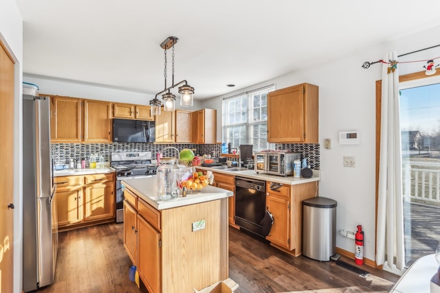 kitchen with hanging light fixtures, dark hardwood / wood-style flooring, backsplash, a kitchen island, and black appliances