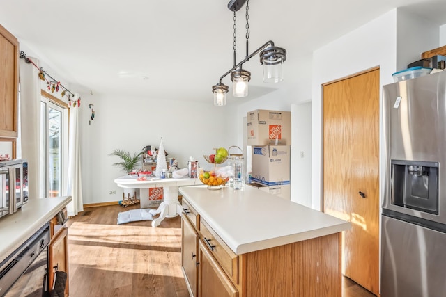 kitchen featuring black dishwasher, light hardwood / wood-style flooring, stainless steel refrigerator with ice dispenser, pendant lighting, and a kitchen island