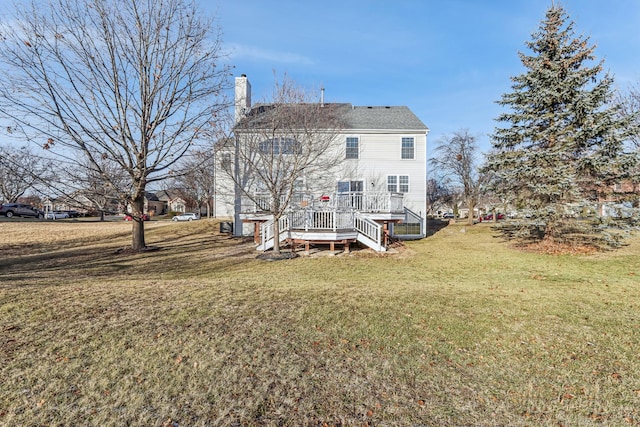 rear view of property featuring a wooden deck and a yard