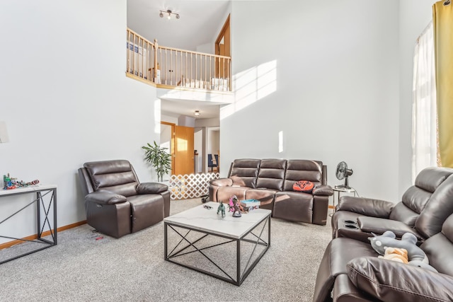 carpeted living room featuring a towering ceiling