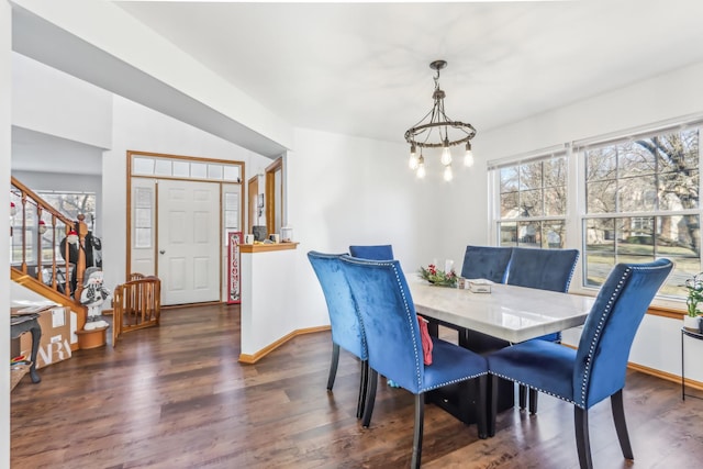 dining area with dark hardwood / wood-style floors and an inviting chandelier