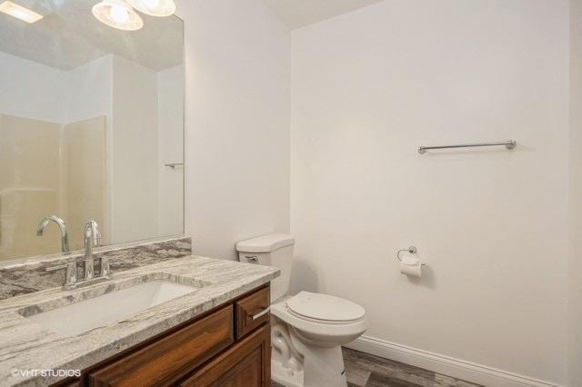 bathroom with hardwood / wood-style floors, vanity, and toilet