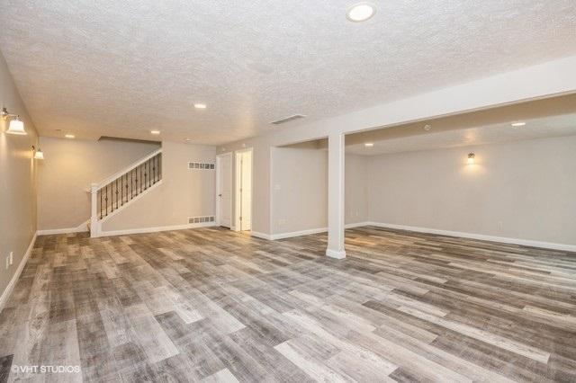 basement with wood-type flooring and a textured ceiling