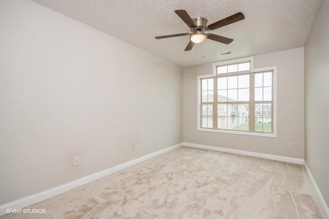 unfurnished room featuring light carpet, a textured ceiling, and ceiling fan