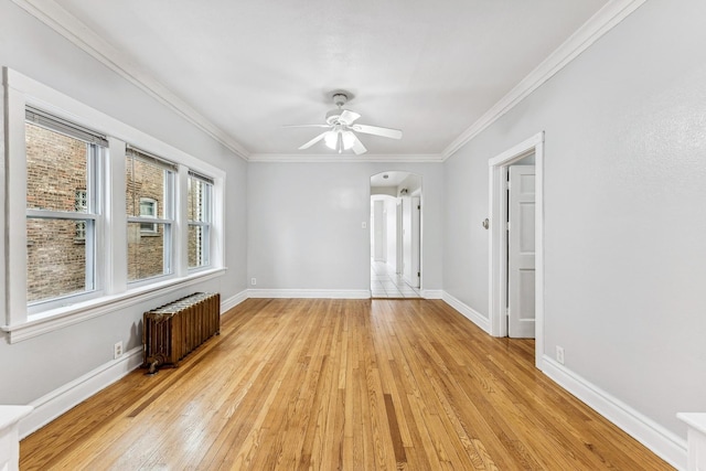 spare room with light hardwood / wood-style flooring, radiator, ornamental molding, and ceiling fan