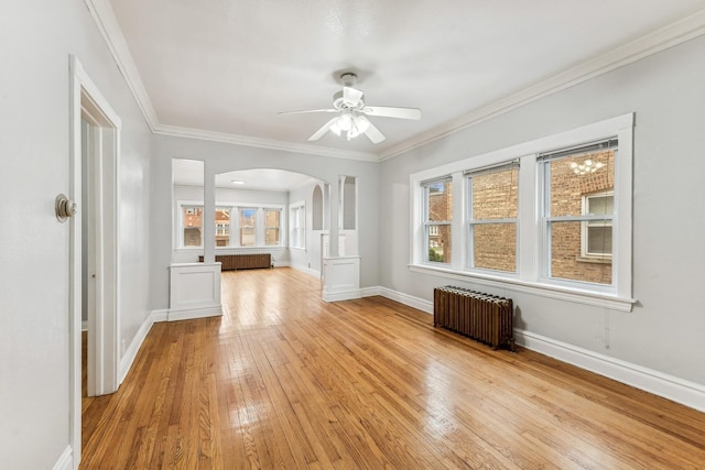 unfurnished living room with ceiling fan, light hardwood / wood-style floors, ornamental molding, and radiator