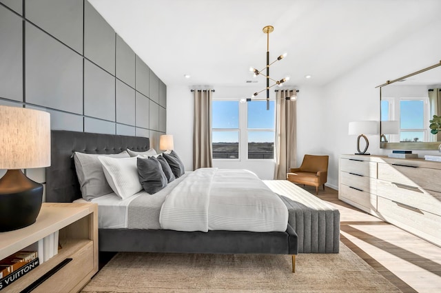 bedroom featuring light hardwood / wood-style floors and an inviting chandelier