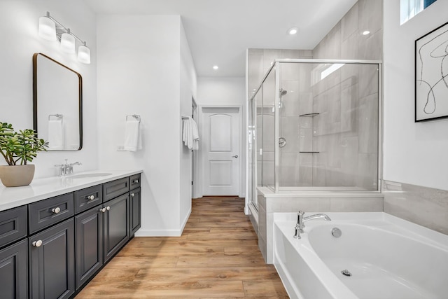 bathroom featuring vanity, wood-type flooring, and shower with separate bathtub