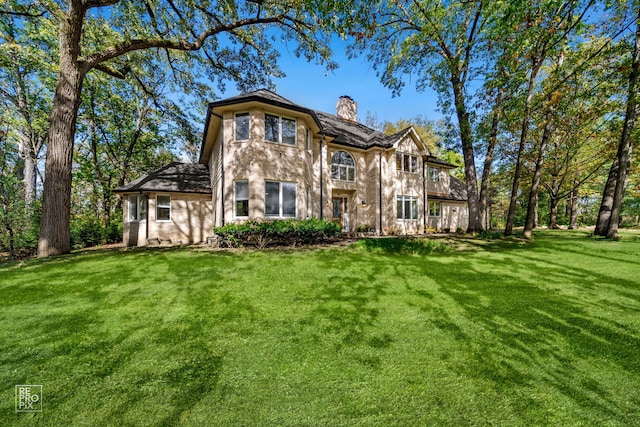 rear view of property featuring a yard