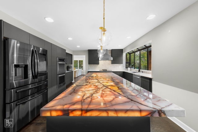 kitchen featuring appliances with stainless steel finishes, tasteful backsplash, a healthy amount of sunlight, and sink