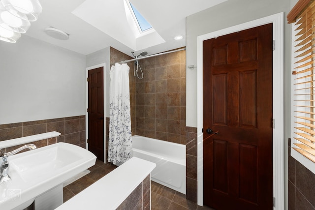 bathroom featuring a wealth of natural light, sink, tile walls, shower / bathtub combination with curtain, and tile patterned flooring