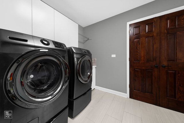 laundry area featuring washer and dryer and cabinets