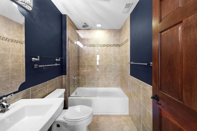 full bathroom featuring sink, tile patterned floors, toilet, tile walls, and tiled shower / bath