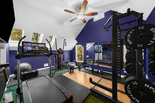 exercise room featuring ceiling fan, wood-type flooring, and lofted ceiling