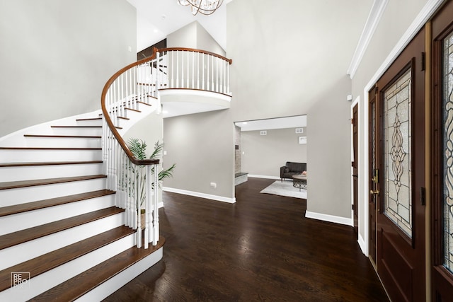 entrance foyer featuring a chandelier, a high ceiling, dark hardwood / wood-style floors, and ornamental molding