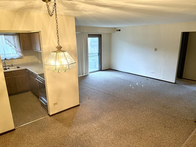 kitchen featuring sink, carpet, and pendant lighting