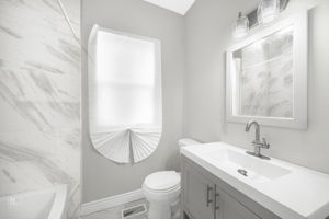 bathroom featuring a bathing tub, vanity, and toilet