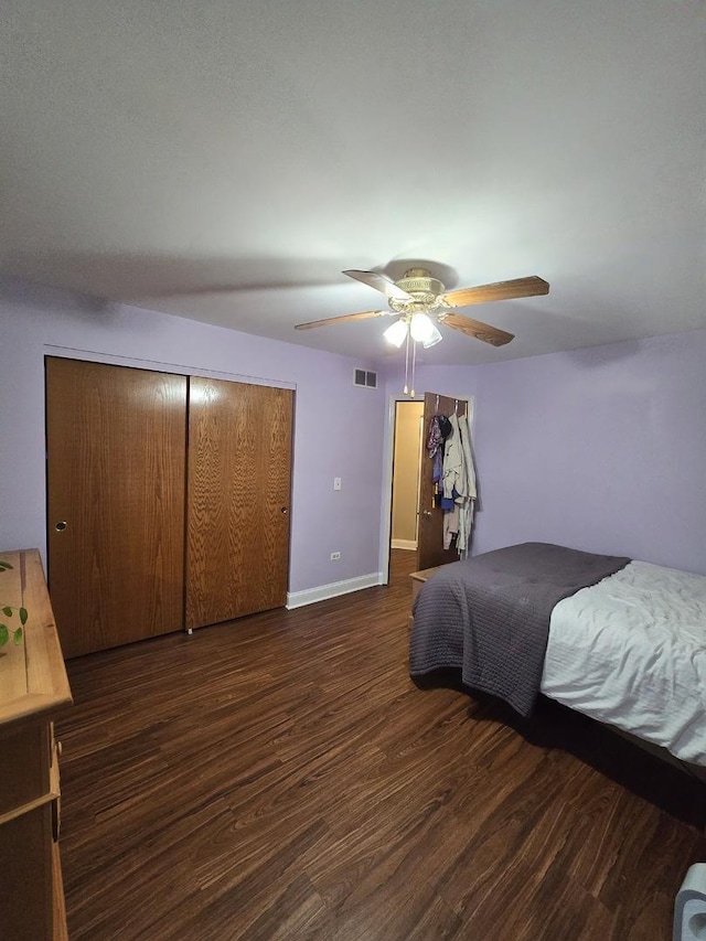 bedroom featuring ceiling fan, dark wood-type flooring, and a closet